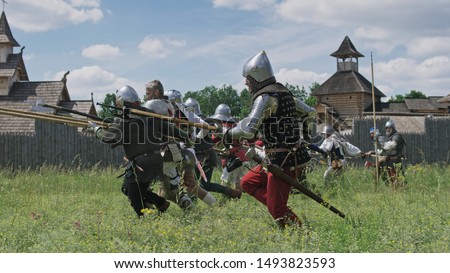 Knights in offensive. Warriors preparing to the attack and the artilleryist shoot from the cannon.