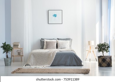 Knit blanket on king-size bed in natural warm bedroom of modern apartment in soft gray and blue colors - Shutterstock ID 753911389