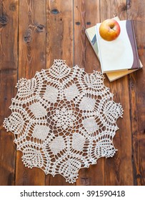 Knited Openwork Crochet Doily Lying On A Wooden Table. View From Above