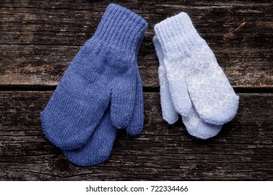 Knitted Blue Mittens On Wood Background