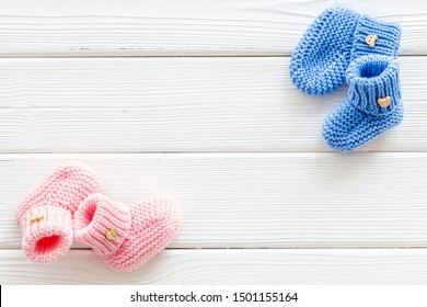 Knitted Blue And Pink Footwear For Baby On White Wooden Background Top View Mockup