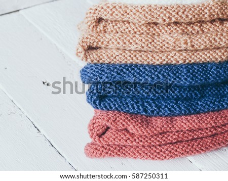 Knitted clothes, pile of knitted multi-colored things. Retro style. Warm concept, selective focus and toned image
