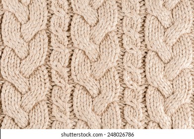 Knitted fabric texture close-up, beige color,  aran Sweater.