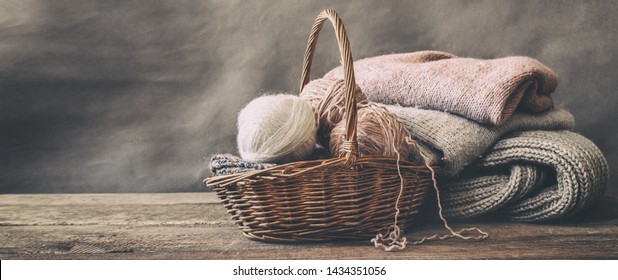 Knitted from a gray yarn sweater and thread for knitting closeup. Knitting as a hobby. Accessories for knitting. - Powered by Shutterstock