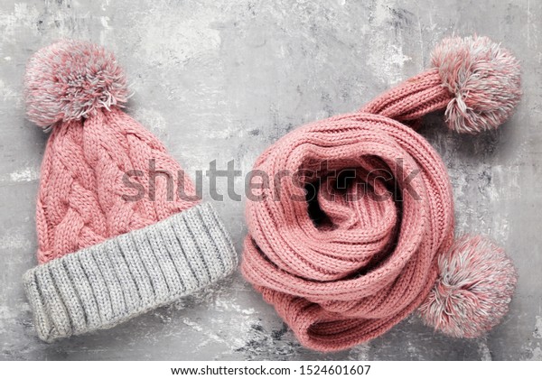 Knitted hat and scarf on\
grey background