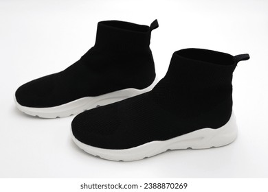 Knitted jogging shoes in black and white on white background