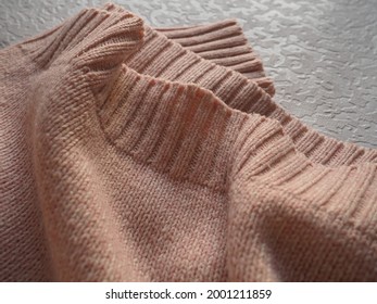 Knitted Knitwear. Knitted Warm Winter Sweater Or Close-up Jumper. Wool Or Polyester Threads. Clothing Production. The Texture Of The Knitted Thing.