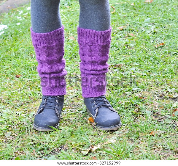 knitted\
leg warmers and shoes on the feet of the\
woman