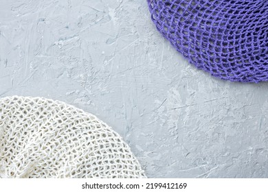 Knitted Purple And White Mesh String Bages, Gray Concrete Background With Art Beads Of Stucco, Copy Space