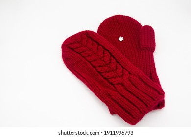 A knitted red mittens with one white snowflake. White background, isolated. Concept of Christmas, winter, love. Care and Valentine's day. Copy space 