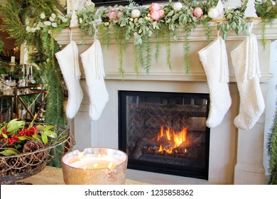 Knitted White Christmas Stockings Hanging On A Fireplace Mantle. 