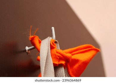 Knitted woolen clothes on a hanger on a brown background - Shutterstock ID 2396364869