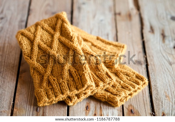 knitted yellow\
leg warmers on wooden\
background