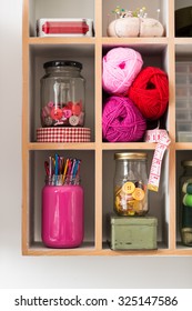 Knitting And Crochet Materials, Jars Of Buttons, Hooks, Thread And Yarn, Organized In Shelf With Rectangular Segments.