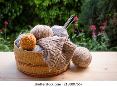 Knitting Yarn And Needles In The Basket On Wooden  Table 