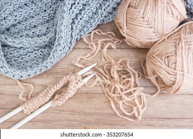 Knitting and yarn on wooden background. Handcraft. Vintage style with dark vignette and color filter warm tone.