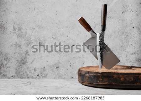 Knive and cleaver sticking out of wooden stump