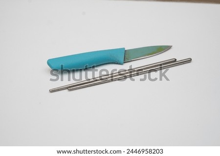 knives and chopsticks placed on a white base