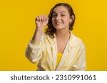 Knock-knock who is there. Excited young woman knocking door gesture asking who is at home, feeling embarrassed, no idea, being clueless and uncertain. Girl isolated alone on studio yellow background