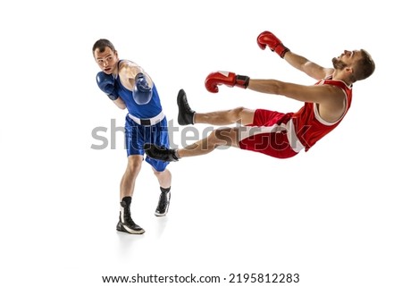 Knockout punch. Two male professional boxers boxing isolated on white studio background. Concept of sport, competition, training, energy. Athletes practicing punch. Copy space for ad, text