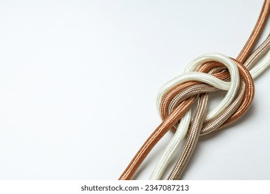 Un nudo de cordones trenzados multicolores sobre un fondo blanco