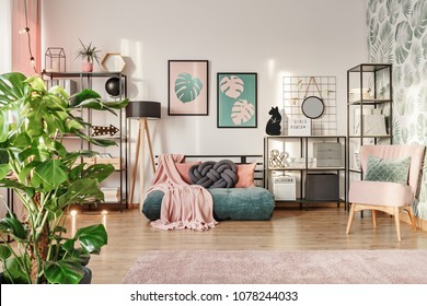 Knot Pillow On A Designer, Emerald Green Mattress Sofa In A Living Room Interior With Industrial Furniture, A Retro Powder Pink Chair And Plants