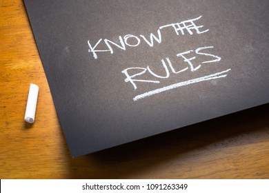 KNOW THE RULES text, handwriting as a note on black paper on the table