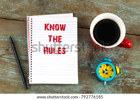  know the rules- text on notepad with, cup of coffee on wooden desk. Top view.