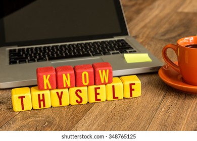 Know Thyself written on a wooden cube in a office desk