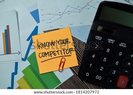 Know Your Competitor write on sticky notes with graphs and diagram isolated on office desk.