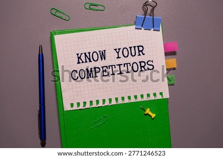 KNOW YOUR COMPETITORS text on a paper on a gray background near a calculator and white keyboard