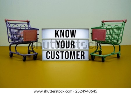 Know Your Customer text on LED lightbox with trolley shopping cart on yellow background