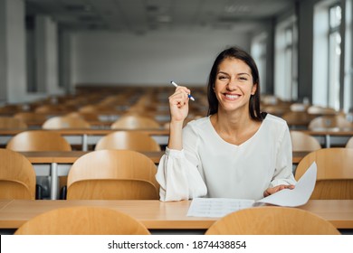 Knowledgable Smiling Student Taking An Easy Exam In An Empty Amphitheater. An Optimistic Student Taking An In-class Test. Happy Woman Having Stress Free Education Evaluation.Essay Exam Inspiration.