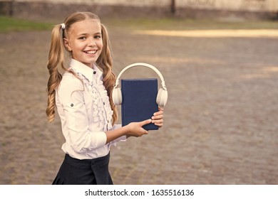 Knowledge assimilate better this way. Audio book concept. Digital technologies for learning. Elearning and modern methods. Girl cute schoolgirl hold book and headphones. Listening school book.