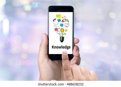 Knowledge   Expertise Intelligence Learn Knowledge person holding a smartphone on blurred cityscape background