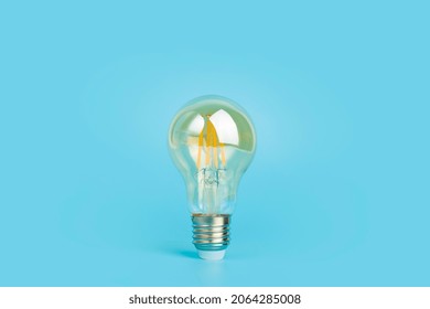 Knowledge and idea concept. Light bulb with light on a blank blue background. Brain, wisdom, knowledge and energy conservation is a creative idea.