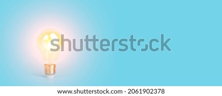 Knowledge and idea concept. Light bulb with light on a blank blue banner background. Brain, wisdom, knowledge and energy conservation is a creative idea.