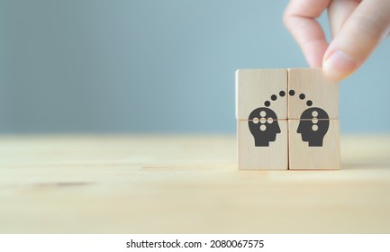 Knowledge and ideas sharing between two people head icon on wooden cube. Transferring knowledge, innovation, brainstorming concept. Business strategies to technology evolution re-skill and new skill. 