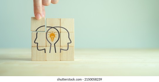 Knowledge and ideas sharing between two people head icon on wooden cube. Transferring knowledge, innovation, brainstorming concept. Business strategies to technology evolution reskill and new skill.  - Shutterstock ID 2150058239
