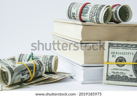 Knowledge leads to wealth. Stack of books with dollars. Concept of expensive education. Money in books. Saving money for college univercity. Savings, paid tuition