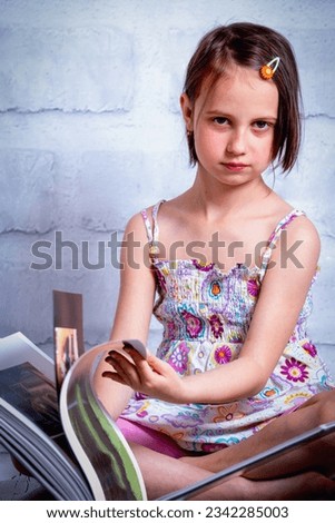 Knowledge and learning concept. Young cute child girl readin the book. Vertical image.