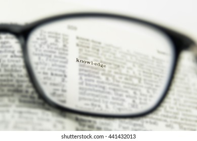 knowledge word close up, view through nearsighted lens glasses, blurred background