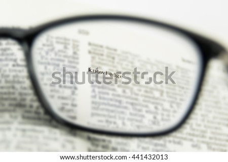 knowledge word close up, view through nearsighted lens glasses, blurred background