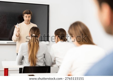 Knowledgeable professor explaining subject to classroom full of students