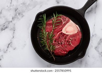 knuckle on the bone, raw meat for ossobuco, in a cast-iron pan, with a sprig of rosemary, top view, marble table, no people. - Powered by Shutterstock