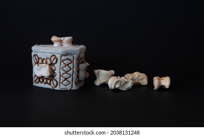 Knucklebones game and felt box. Close up photography on black background