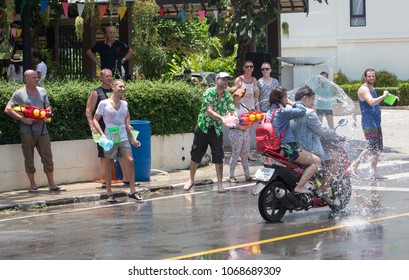 Ko Chang (Thailand) - April 13, 2018. People enjoy outdoor water splashing during hot summer day in the main road of Ko Chang Island, Trat Province, in Thailand’s traditional New Year (Songkran).