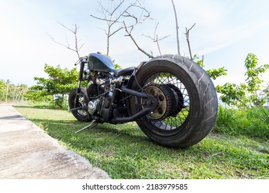 Ko Lanta, Ko Lanta District, Krabi 81150, Thailand  May 14th 2018  A Custom Chopper Motorbike Parked On Grass Next To A Tropical Beach. Rat Bike, Low Rider, Honda Engine