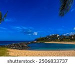 The Ko Olina Lagoons under a brilliant blue sky with palm trees and sandy beaches