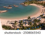 Ko Olina, Oahu, Hawaii lagoon, beach and Pacific Ocean showing the straw umbrellas, blue beach chairs on the sand of the beautiful lagoon.  This is on the West side of Oahu and a great vacation place.